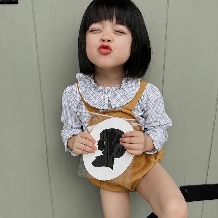 Toddler holding a silhouette cut out craft from attending a Broomtail event