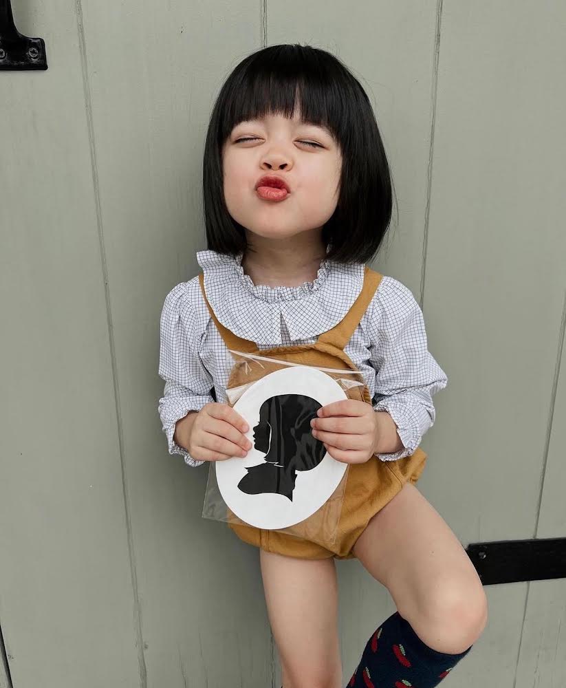 Toddler holding a silhouette cut out craft from attending a Broomtail event