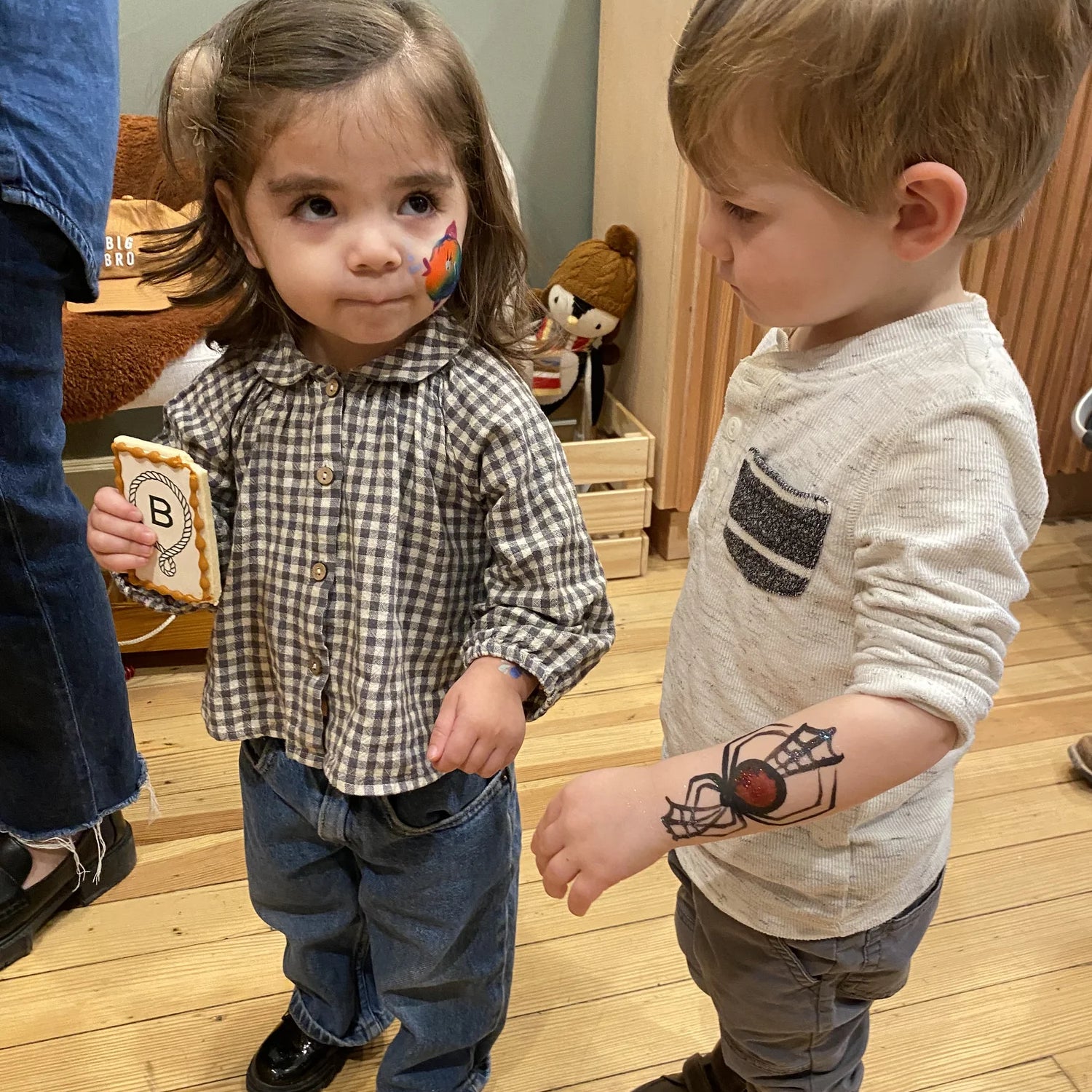 Two toddlers at a Broomtail event with cookies and tattoos