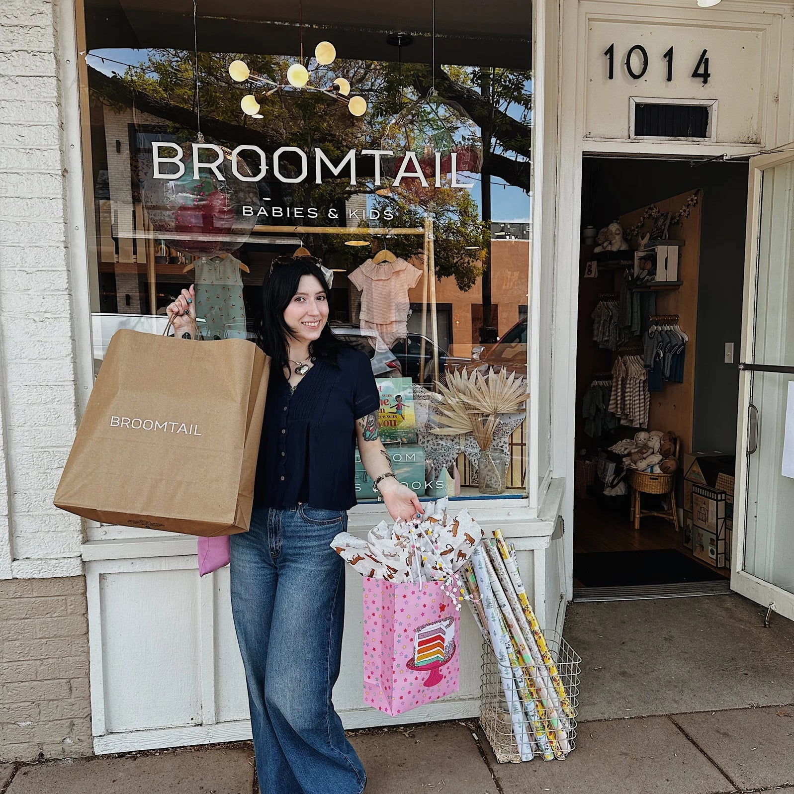 Women holding shopping bags and birthday gifts in front of Broomtail