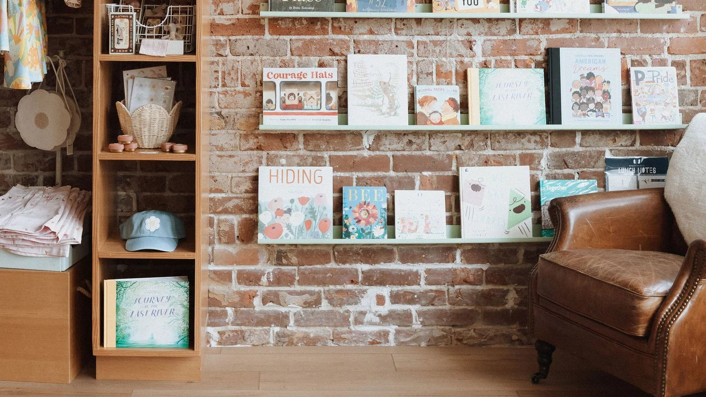 Shelves with books and decorative items against a brick wall at a Broomtail location.